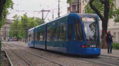 Modern mavi tramvay bombacısı şehirden geçiyor. Toplu taşımanın modernizasyonu. Çevre dostu ulaşım aracı. Tramvay tasarımında yeni teknolojiler. Krakow, Polonya 18.05.2020