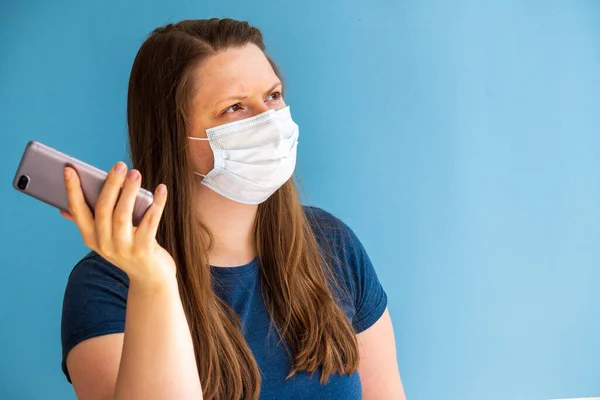 Europäische Bloggerin Medizinischer Maske Auf Blauem Hintergrund Mit Handy Der — Stockfoto