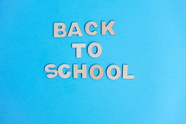 Study flatly concept. Education process after coronovirus with medical mask and sanitizer on blue background, back to school or kindergarten. summertime and learn. Woody school inscription, banner.