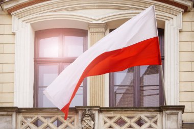 Bloğun veya evin duvarında rüzgarda dalgalanan Polonya beyaz bayrağı. Doğal Işık Seçici Odaklanma. Bina manzarası. 1 Mayıs, 11 Kasım, bayrak ya da bağımsızlık günü. Hükümet bayramı, Başkan oylaması
