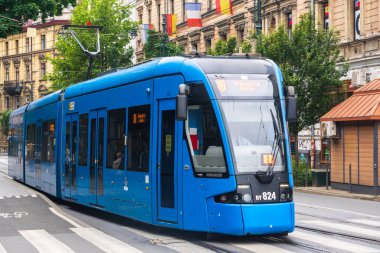 Polonya, Krakow 02.22.2020: Şehir merkezindeki modern mavi tramvay. Çevre dostu şehir toplu taşımacılığı. Kentsel ormancılık, çevrenin korunması.