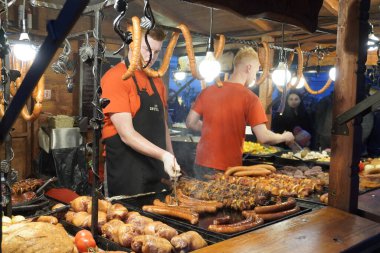 Yeni yılda güzel ya da yemek festivali ya da eski kasabada Noel. Turistler için geleneksel yemek pişirmek. Ekmek, sosis, sebzelerle birlikte ateşte kızartılmış. Krakow, Polonya-06.01.2020