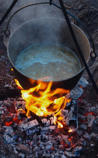 Preparing food on campfire pot