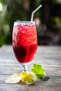 Roselle suyu buz üzerinde. Kahverengi ahşap zemin üzerinde organik sağlıklı