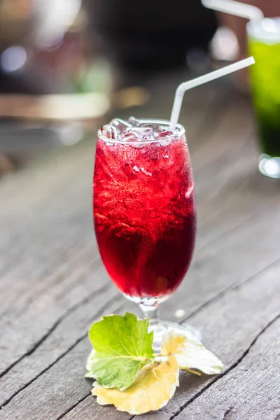 Roselle suyu buz üzerinde. Kahverengi ahşap zemin üzerinde organik sağlıklı