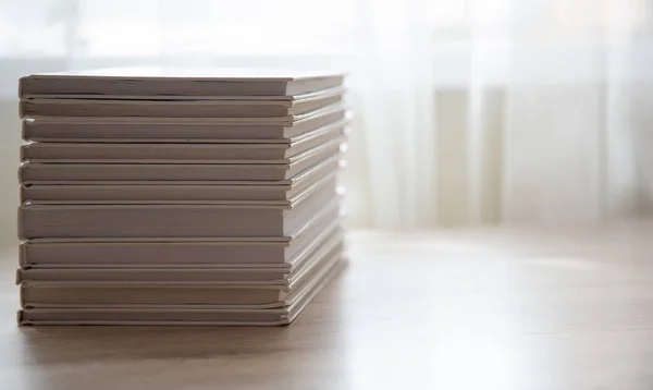 White books on a table on a white background, stacked on top of each other