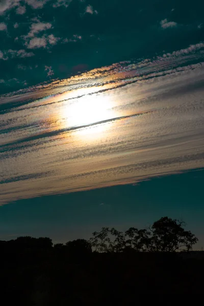 一个不寻常的景观 傍晚的夜空 太阳隐藏在一个不寻常的云彩形状后面 — 图库照片