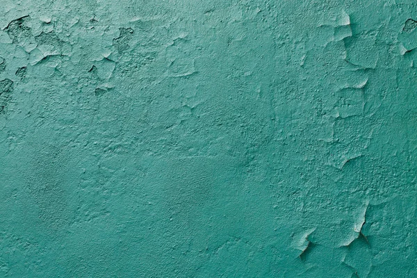 Green cracked green painted wall background. Metal texture with scratches and cracks