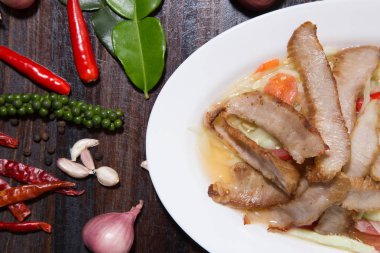 Beyaz tabakta yeşil salata ile Dilimlenmiş domuz kavrulmuş Tay tarzı