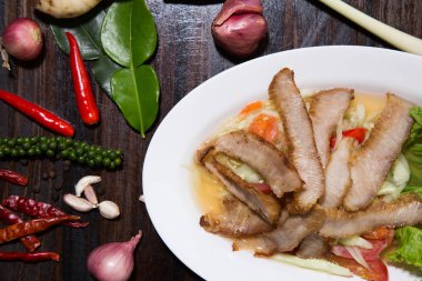 Beyaz tabakta yeşil salata ile Dilimlenmiş domuz kavrulmuş Tay tarzı