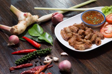 Kızarmış domuz eti ince bağırsak ya da domuz iç organları baharatlı sos ile servis edilir.