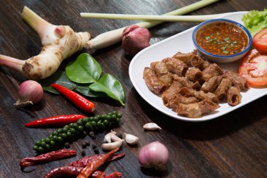 Kızarmış domuz eti ince bağırsak ya da domuz iç organları baharatlı sos ile servis edilir.