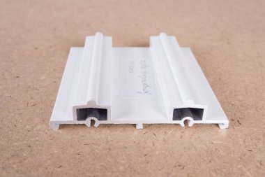 PVC penceresinin bir kesiti. PVC pencere profili kesildi. Pencere için pvc profillerinin tasarımı, arkaplanda teknik çizim