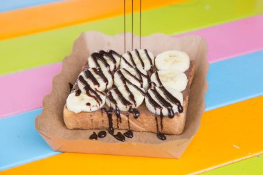 ekmek tost tereyağı çikolata nutella üstüne muz ve çikolata sosu ile 