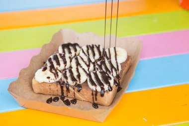 ekmek tost tereyağı çikolata nutella üstüne muz ve çikolata sosu ile 