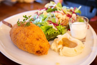 Pirzola, domuz jambonlu, haşlanmış patates ve tabakta salata.. 