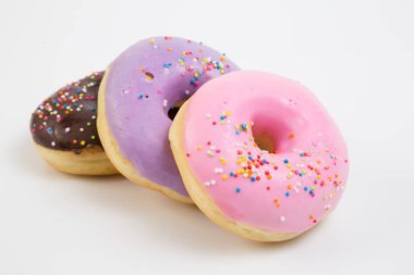 Çörek. Tatlı krema şeker yiyecek. Tatlı renkli aperatif. Sırlı sprinkles. Lezzetli pasta kahvaltı tedavi. Ekmek pasta. Halka buzlanma ile. Sağlıksız yuvarlak pişmiş.