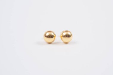 Beyaz zemin üzerine altın küpe.