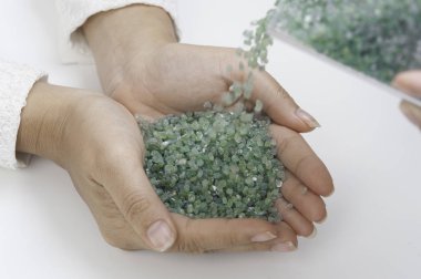 Beyaz arka plan üzerinde elinde Kaba yeşil Peridot değerli taş.