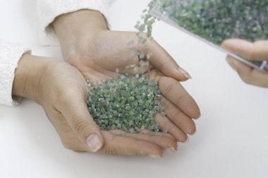 Beyaz arka plan üzerinde elinde Kaba yeşil Peridot değerli taş.