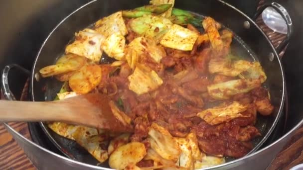 Mężczyzna pomóc kobiecie mieszać ryż z Takkalbi lub Dakgalbi (pikantny kurczak grill) — Wideo stockowe