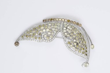 Beyaz arka planda kelebek şeklinde elmas broş.