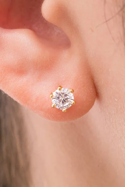 Gold earrings stud with diamonds macro shot.