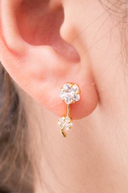 Altın çiçek şeklinde küpe.