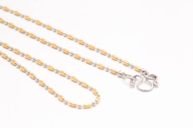 Beyaz arka plan üzerinde altın kolye iki ton.