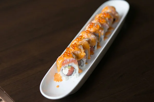 California salmon sushi rolls stuffed with salmon, avocado, topping salmon roe and spicy cream sauce. Japanese food style