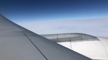 Uçağın penceresi. Güzel beyaz bulutlar mavi gökyüzüne karşı.