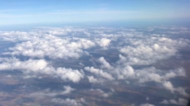 Uçan ve pencereden bakan uçakta otururken gökyüzünü, bulutları ve karayı görüyorum. Doğa manzaralı mavi gökyüzü ile özgürlüğü hissetmek ve her zaman yeni bir ilham kaynağı olmak ve rahatlama yolculuğu hissetmek.