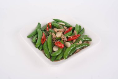 Tayland yemeği, kızarmış bezelye ve beyaz tabakta istiridye sosu.