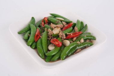 Tayland yemeği, kızarmış bezelye ve beyaz tabakta istiridye sosu.