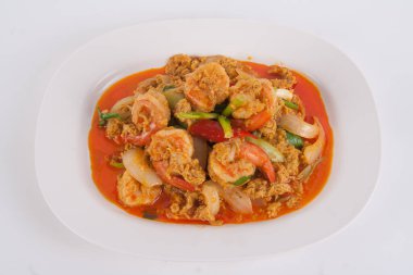 Masada beyaz tabakta köri tozu ile kızarmış karidesi karıştır