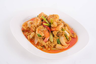 Masada beyaz tabakta köri tozu ile kızarmış karidesi karıştır