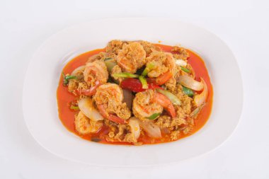 Masada beyaz tabakta köri tozu ile kızarmış karidesi karıştır