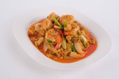 Masada beyaz tabakta köri tozu ile kızarmış karidesi karıştır