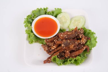 Kızarmış biftek dilimi ve beyaz arka planda lezzetli bir tat veren otlar.