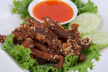 Kızarmış biftek dilimi ve beyaz arka planda lezzetli bir tat veren otlar.