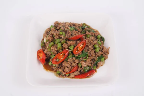 Kızarmış domuz kıyması ve beyaz tabakta fesleğen.