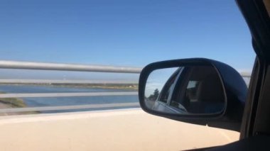 Kamera, bir aracın sürücü tarafındaki camından dışarı bakıyor.