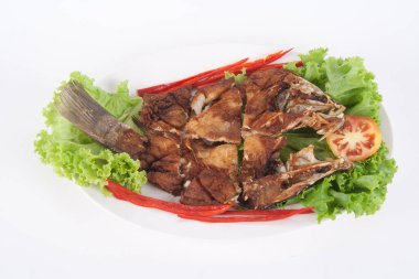 Beyaz seramik tabakta soslu kızarmış balık restorandaki en popüler Tayland yemeğidir..