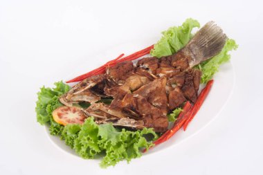 Beyaz seramik tabakta soslu kızarmış balık restorandaki en popüler Tayland yemeğidir..