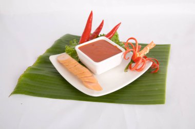 Aperatif dilimlenmiş sosis ve biber sosu.