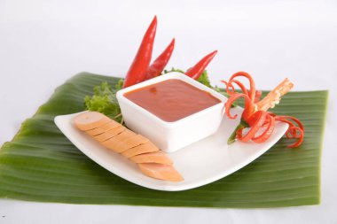 Aperatif dilimlenmiş sosis ve biber sosu.