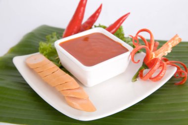 Aperatif dilimlenmiş sosis ve biber sosu.