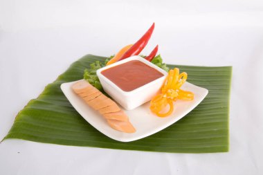 Aperatif dilimlenmiş sosis ve biber sosu.