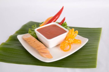 Aperatif dilimlenmiş sosis ve biber sosu.