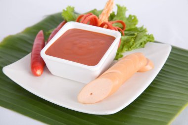 Aperatif dilimlenmiş sosis ve biber sosu.